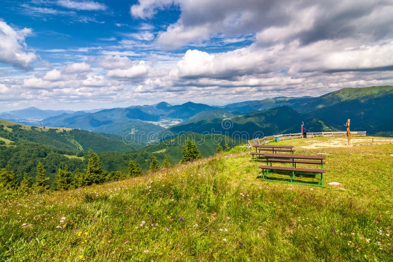 Jarná krajina s trávnatými lúkami a horskými štítmi