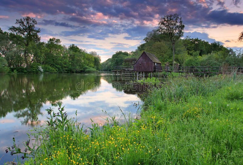 Spring landscape at sunset with watermill