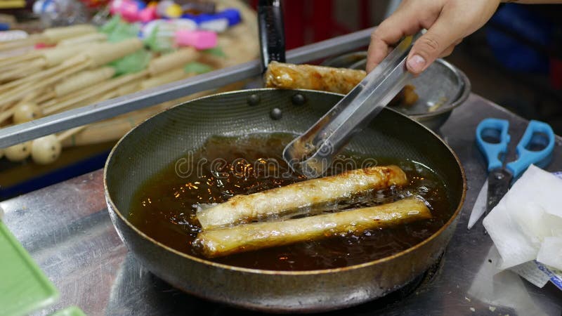 Spring roll in frying pan at asian street food night market. Vietnamese food. Closeup.4k