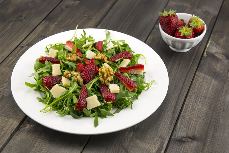 Spring salad with strawberries, rocket salad, parmesan cheese, w royalty free stock photography