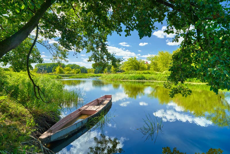 Primavera, estate, paesaggio, cielo azzurro nuvole Narew barca del fiume verde di alberi di campagna, erba Polonia acqua foglie.