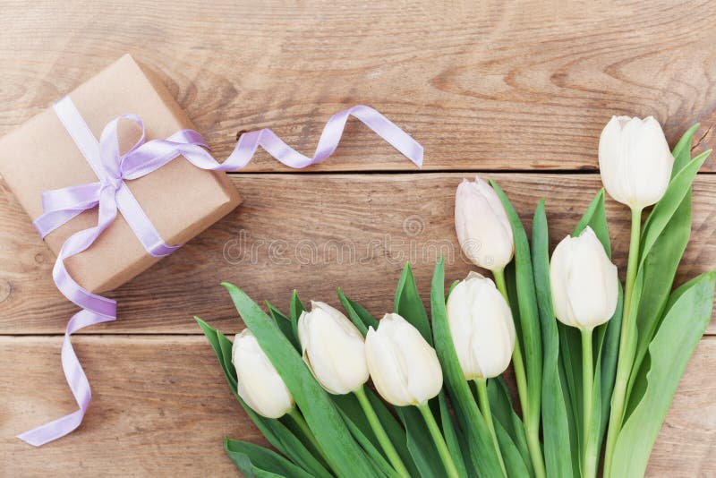 Spring tulip flowers and gift box on vintage table top view in flat lay style. Greeting card for Birthday, Woman or Mothers Day. royalty free stock image Spring tulip flowers and gift box on vintage table top view in flat lay style. Greeting card for Birthday, Woman or Mothers Day. royalty free stock image