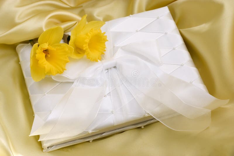 Spring wedding guest book on yellow satin with daffodils. Atlas book stock images, royalty-free photos and pictures