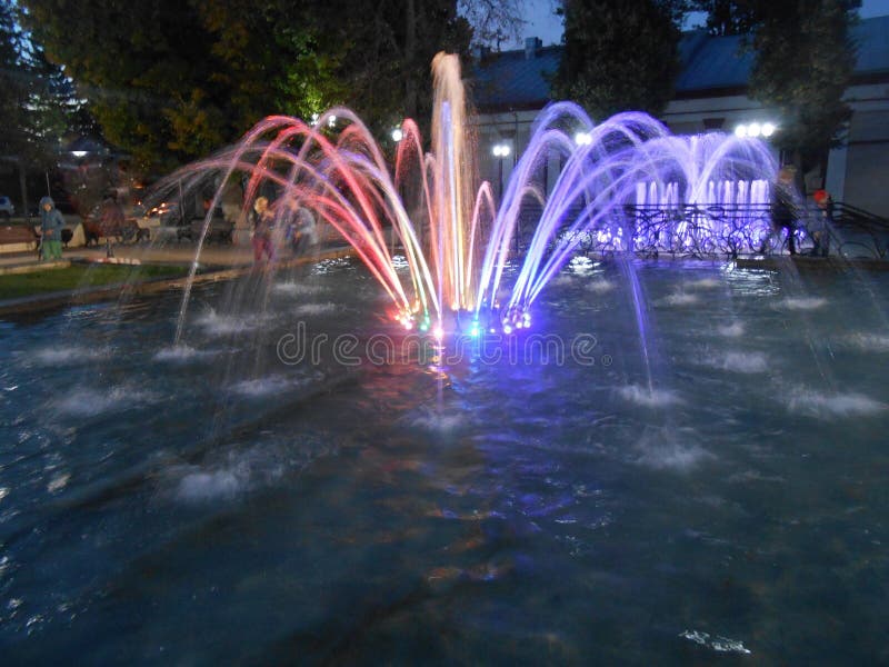 Night violet-red fountain with splashes in the night in town. Night violet-red fountain with splashes in the night in town.