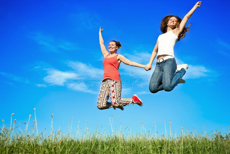 Springen der jungen Frauen des Glückes
