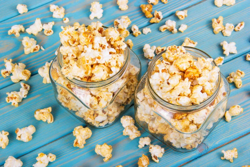 Sprinklad sockerkulör, sockerkulör, popcorn. popcorn i glasburkar. Utsökt, krispisk, smaksatt popcorn. royaltyfria bilder