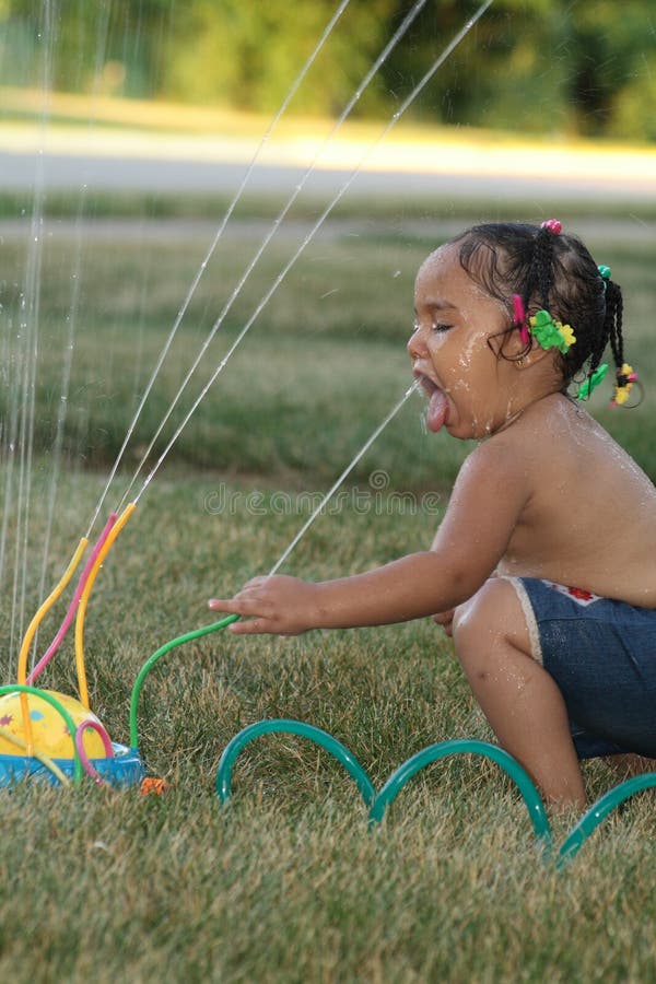 Un bambino di ottenere una bevanda dal suo sprinkler.