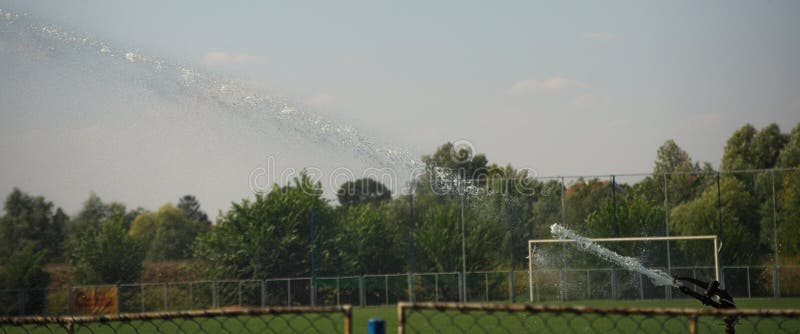 Sprinkler watering grass lawn at football field royalty free stock image Sprinkler watering grass lawn at football field royalty free stock image