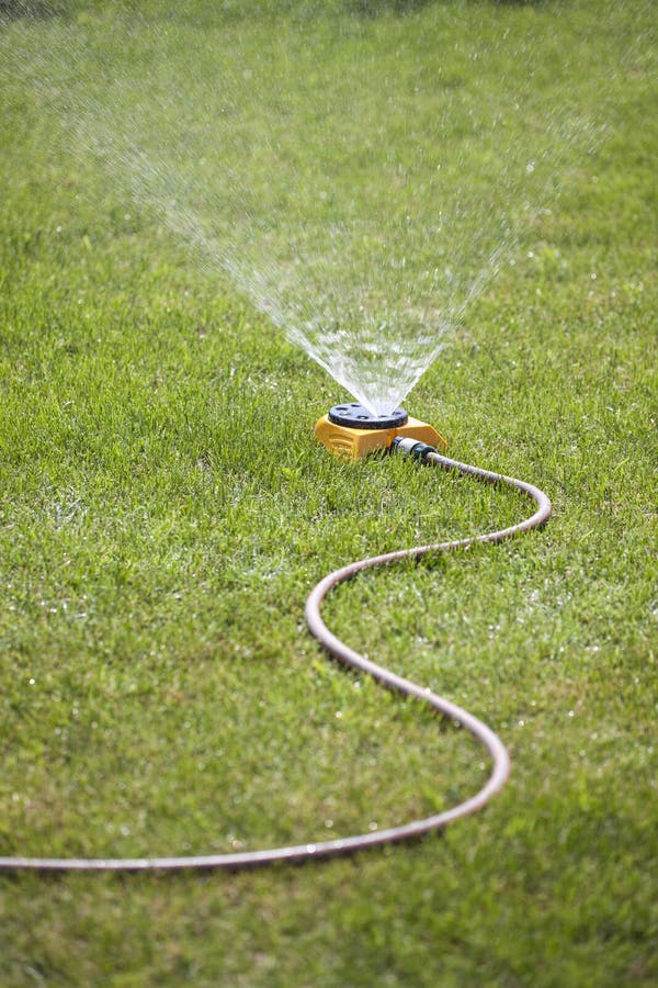 Sprinkler watering the lawn stock photos