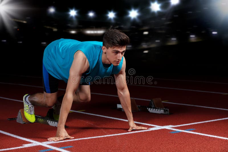 Sprinter που αφήνει τους αρχικούς φραγμούς στην τρέχοντας διαδρομή μπροστά από το μεγάλο σύγχρονο στάδιο με τα φω'τα explosive st στοκ φωτογραφίες με δικαίωμα ελεύθερης χρήσης Sprinter που αφήνει τους αρχικούς φραγμούς στην τρέχοντας διαδρομή μπροστά από το μεγάλο σύγχρονο στάδιο με τα φω'τα explosive st στοκ φωτογραφίες με δικαίωμα ελεύθερης χρήσης