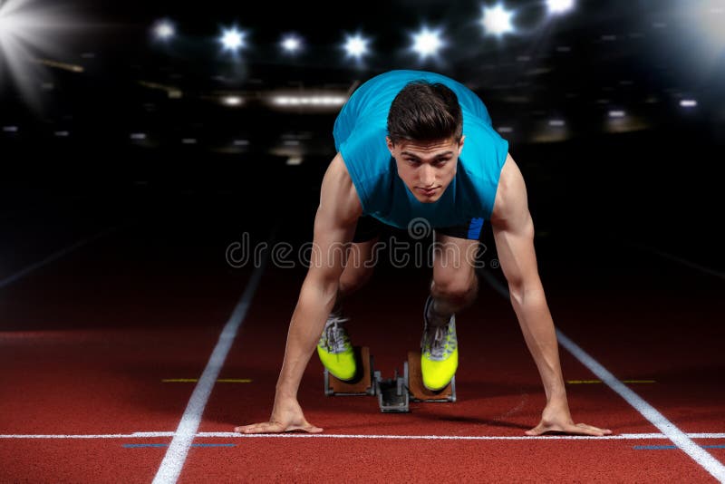 Sprinter που αφήνει τους αρχικούς φραγμούς στην τρέχοντας διαδρομή μπροστά από το μεγάλο σύγχρονο στάδιο με τα φω'τα explosive st στοκ εικόνες με δικαίωμα ελεύθερης χρήσης Sprinter που αφήνει τους αρχικούς φραγμούς στην τρέχοντας διαδρομή μπροστά από το μεγάλο σύγχρονο στάδιο με τα φω'τα explosive st στοκ εικόνες με δικαίωμα ελεύθερης χρήσης