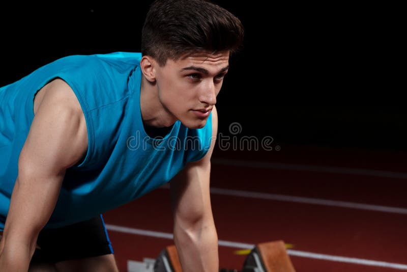 Sprinter που αφήνει τους αρχικούς φραγμούς στην τρέχοντας διαδρομή μπροστά από το μεγάλο σύγχρονο στάδιο με τα φω'τα explosive st στοκ εικόνες με δικαίωμα ελεύθερης χρήσης Sprinter που αφήνει τους αρχικούς φραγμούς στην τρέχοντας διαδρομή μπροστά από το μεγάλο σύγχρονο στάδιο με τα φω'τα explosive st στοκ εικόνες με δικαίωμα ελεύθερης χρήσης