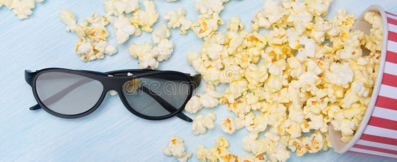 Spritt på ett ljust - grå bakgrund, popcorn i en hink och 3 D-exponeringsglas arkivbild Spritt på ett ljust - grå bakgrund, popcorn i en hink och 3 D-exponeringsglas arkivbild