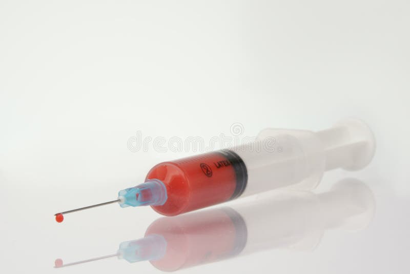 Spritze mit Blutstropfen, Fokus auf Spritze und Reflex stockbilder Spritze mit Blutstropfen, Fokus auf Spritze und Reflex stockbilder