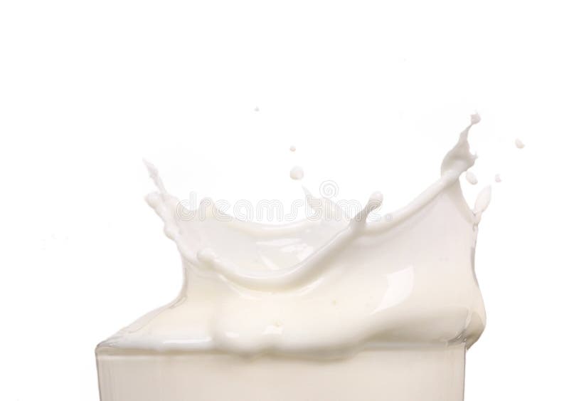 Schizzi di latte in un bicchiere immagine stock