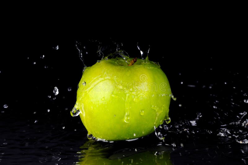 Spruzzata dell'acqua dolce sulla mela verde fotografia stock Spruzzata dell'acqua dolce sulla mela verde fotografia stock