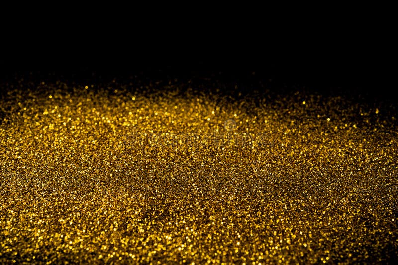 Sprinkle gold dust on a black background with copy space. Sprinkle gold dust on a black background with copy space.