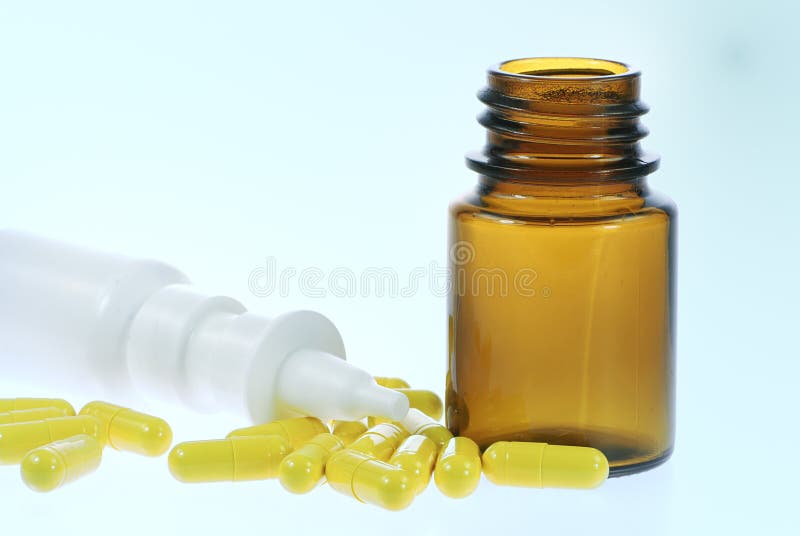 Nasal spray and yellow medical capsules. Nasal spray and yellow medical capsules