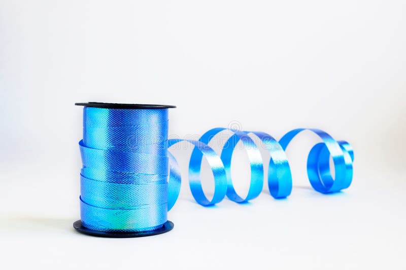 Spule der blauen Windenbandrolle für Geschenkverpackungskunst und des Handwerks auf weißem Hintergrund Selektiver Fokus, Kopienra stockbild Spule der blauen Windenbandrolle für Geschenkverpackungskunst und des Handwerks auf weißem Hintergrund Selektiver Fokus, Kopienra stockbild