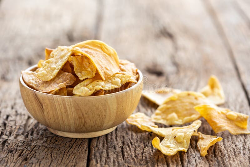 Spuntino tailandese di stile Igname affettato dolce ed asciutto sulla tavola di legno immagini stock libere da diritti Spuntino tailandese di stile Igname affettato dolce ed asciutto sulla tavola di legno immagini stock libere da diritti