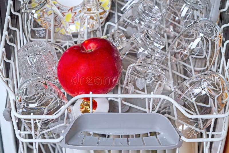 Spülmaschine mit sauberen Tellern und Apfel lizenzfreie stockbilder Spülmaschine mit sauberen Tellern und Apfel lizenzfreie stockbilder
