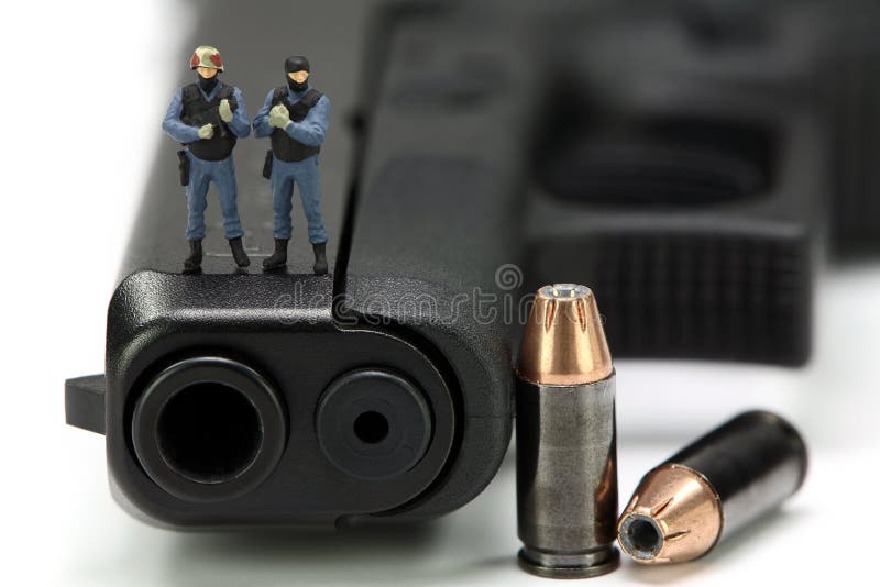 Squadra di SCHIAFFO miniatura che si leva in piedi su una pistola. fotografia stock libera da diritti Squadra di SCHIAFFO miniatura che si leva in piedi su una pistola. fotografia stock libera da diritti