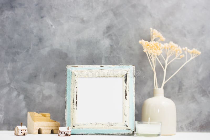 Square blue Photo frame mock up with dry beige plants in vase, wooden houses on shelf. Scandinavian style stock images