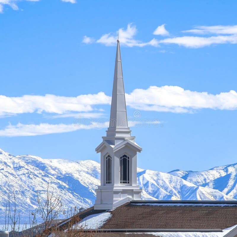 Square frame Rooftop of church with a modern spire design against snowy mountain and lake