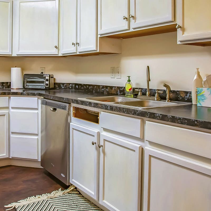 Square Interior of a Kitchen with White and Counters Built Against the Wall Stock Photo