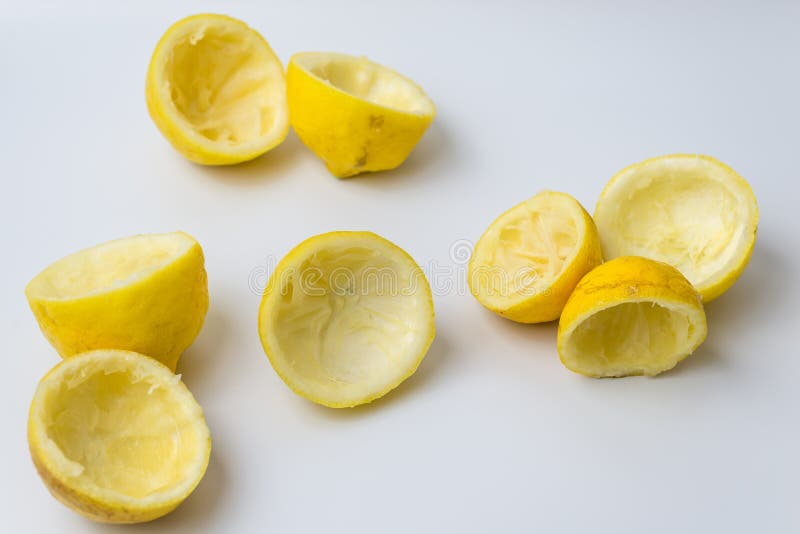 Squeezed lemon peels after making a fresh juice on white background