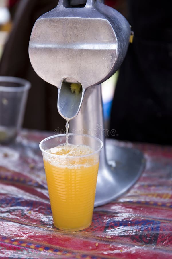 Squeezing Fresh Lemon Juice with Wooden Reamer into Bowl Stock Photo