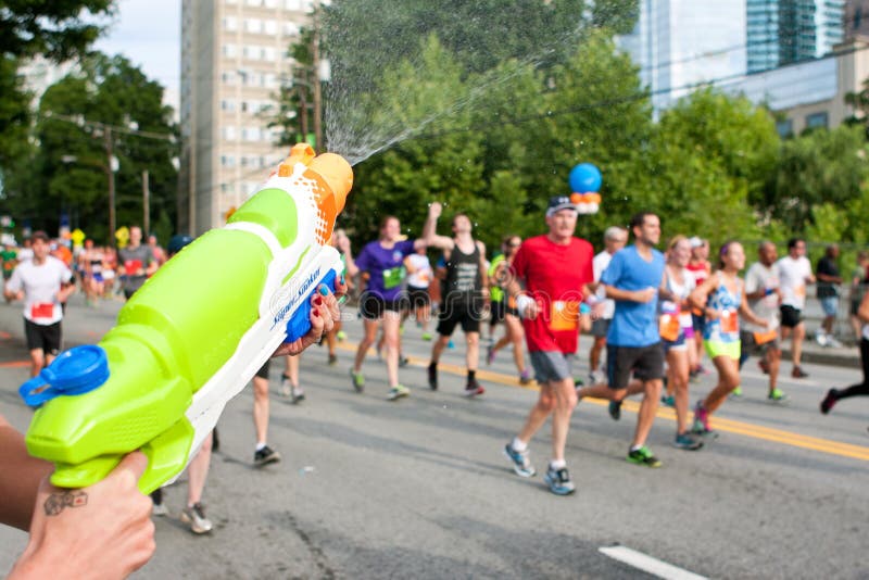 Squirt оружие выдерживает бегунов в гонке дороги Атланты Peachtree стоковое фото Squirt оружие выдерживает бегунов в гонке дороги Атланты Peachtree стоковое фото