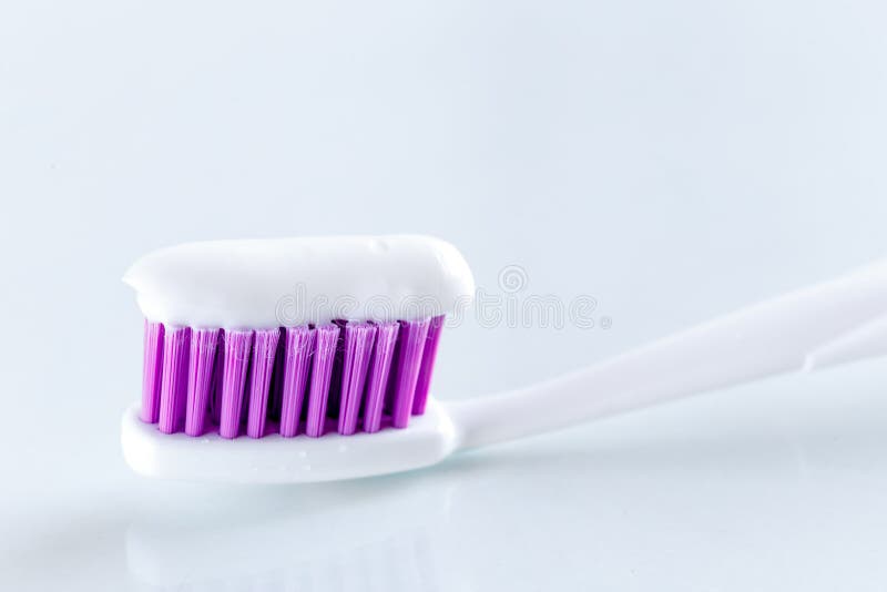 Sqweezed purple toothbrush on white background royalty free stock photo