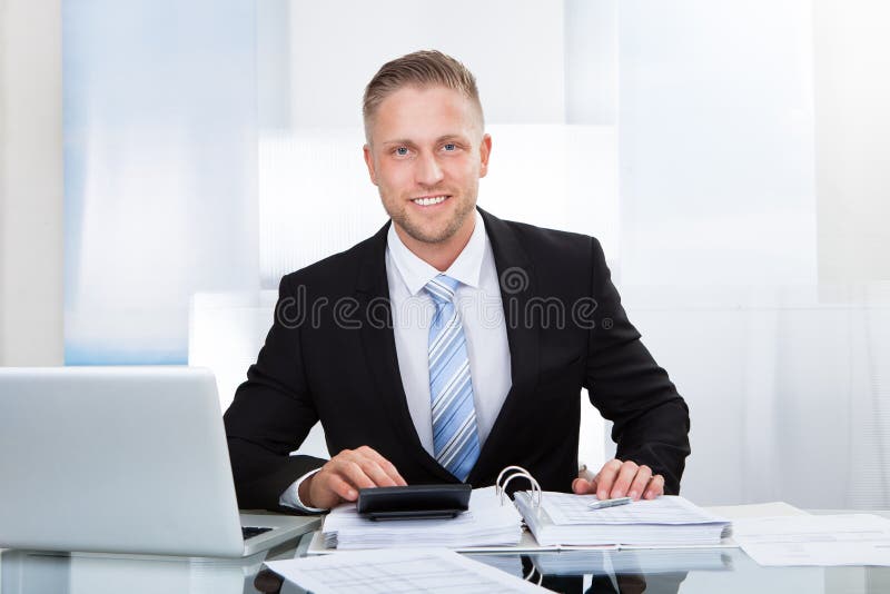 St acertado sonriente del hombre de negocios su escritorio imagenes de archivo St acertado sonriente del hombre de negocios su escritorio imagenes de archivo