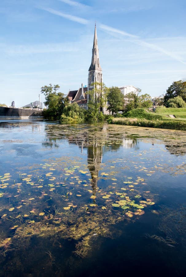 St Alban`s Anglican Church in Copenhagen and its reflection in the lake on a nice summer day. Architecture concept
