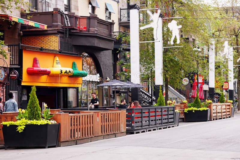 Άνθρωποι καθισμένοι σε καφέ και μπαρ στην περίφημη οδό St. Denis στο Μόντρεαλ στοκ εικόνα με δικαίωμα ελεύθερης χρήσης