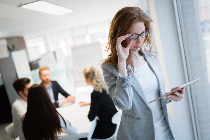 St?ende av attraktiva aff?rspartners som anv?nder minnestavlan arkivbild St?ende av attraktiva aff?rspartners som anv?nder minnestavlan arkivbild