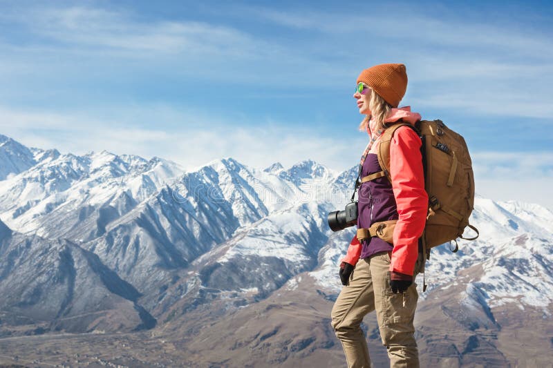 St?ende av den turist- flickan f?r fotografhipster med en kamera i solglas?gon och en hatt mot bakgrunden av sn? arkivfoto St?ende av den turist- flickan f?r fotografhipster med en kamera i solglas?gon och en hatt mot bakgrunden av sn? arkivfoto