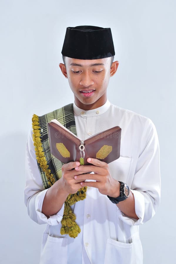 St?enden av den stiliga unga muslim mannen tycker om att l?sa tilawatul-quran en helig Quran i Ramadan royaltyfria bilder St?enden av den stiliga unga muslim mannen tycker om att l?sa tilawatul-quran en helig Quran i Ramadan royaltyfria bilder