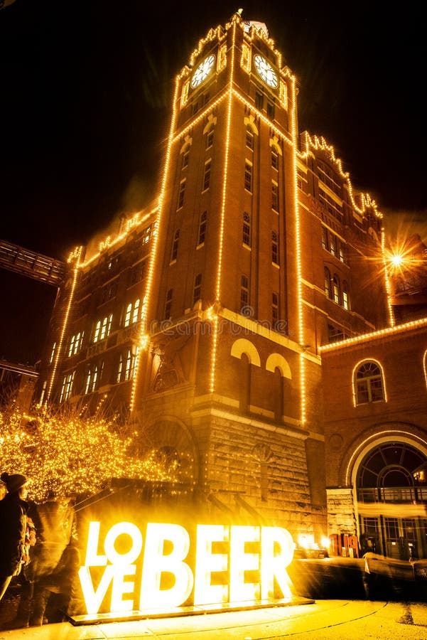 Trees decorated with christmas lights anheuser busch brewery historic clock tower winter st louis at night, Love Beer sign brightly lit up. Trees decorated with christmas lights anheuser busch brewery historic clock tower winter st louis at night, Love Beer sign brightly lit up