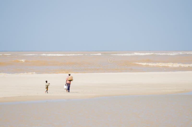 St. Louis, Senegal - 12 de octubre de 2013: Pescador africano y su hijo que caminan a lo largo del océano en la playa fotografía de archivo St. Louis, Senegal - 12 de octubre de 2013: Pescador africano y su hijo que caminan a lo largo del océano en la playa fotografía de archivo