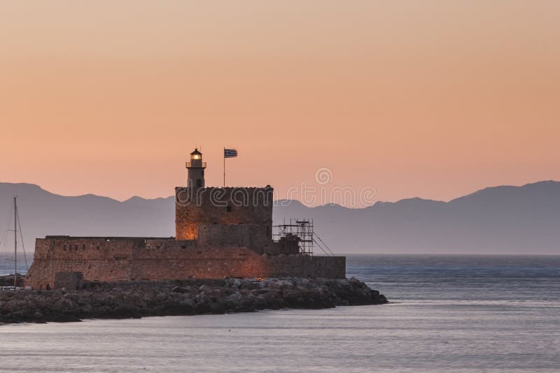 St Nicholas Fortress e farol no por do sol Ilha do Rodes Greece foto de stock royalty free St Nicholas Fortress e farol no por do sol Ilha do Rodes Greece foto de stock royalty free