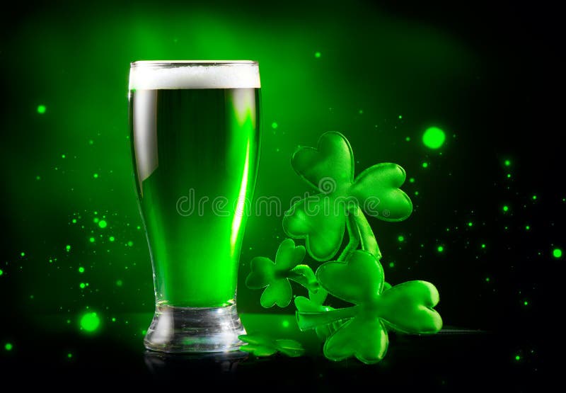 St. Patrick`s Day Green Beer pint over dark green background, decorated with shamrock leaves. Patrick Day Irish pub party, celebrating. Glass of Green beer close-up. Border art design