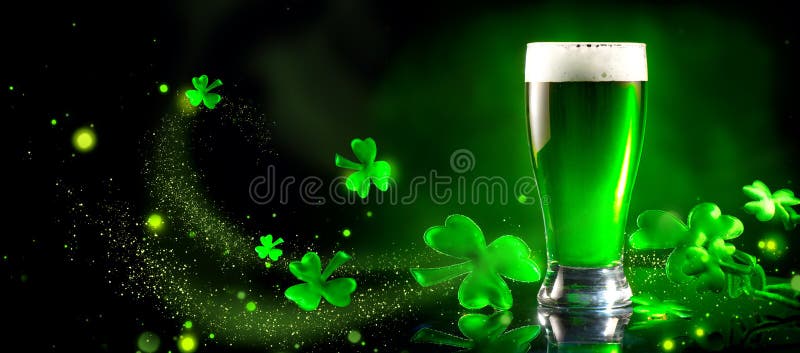 St. Patrick`s Day. Green beer pint over dark green background, decorated with shamrock leaves. Traditional Irish festival