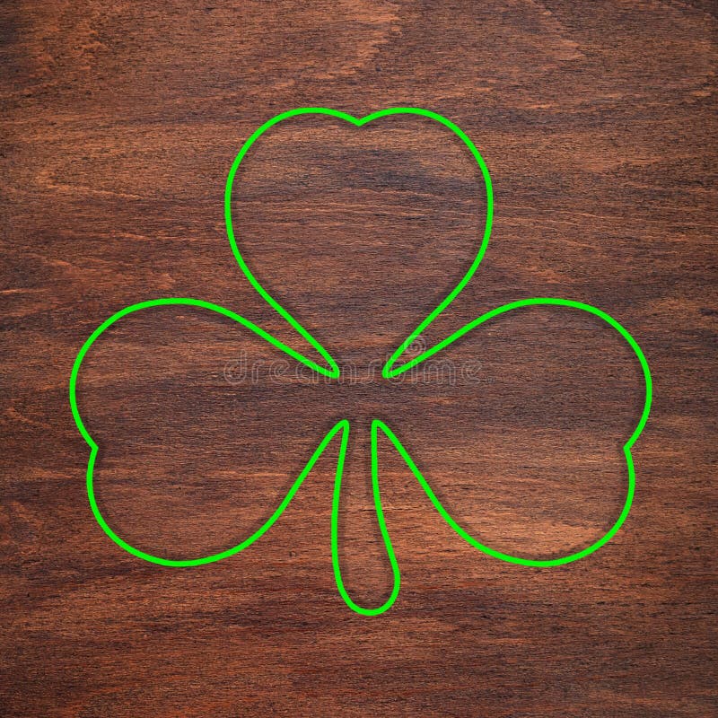 St. Patrick`s Day. Green shamrock outline is drawn on a wooden surface. Three leaf clover stock images