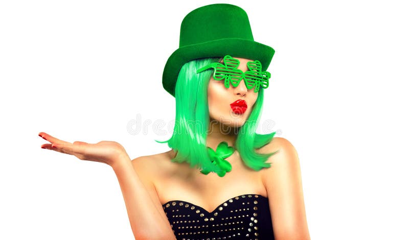 St. Patrick`s Day leprechaun model girl in green hat, funny clover sunglasses holding product, pointing hand, isolated on white stock photos St. Patrick`s Day leprechaun model girl in green hat, funny clover sunglasses holding product, pointing hand, isolated on white stock photos