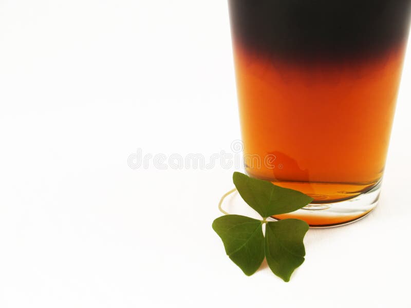 Black and tan beer in a pint glass with a shamrock. Black and tan beer in a pint glass with a shamrock