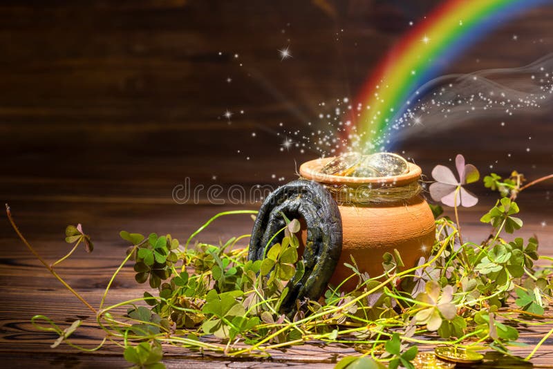 St Patricks day decoration with magic light rainbow pot full gold coins, horseshoe and shamrocks on vintage wooden background, cl