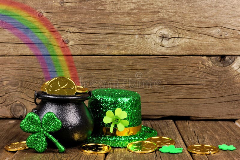 St Patricks Day Pot of Gold with rainbow, shamrocks and hat against rustic wood