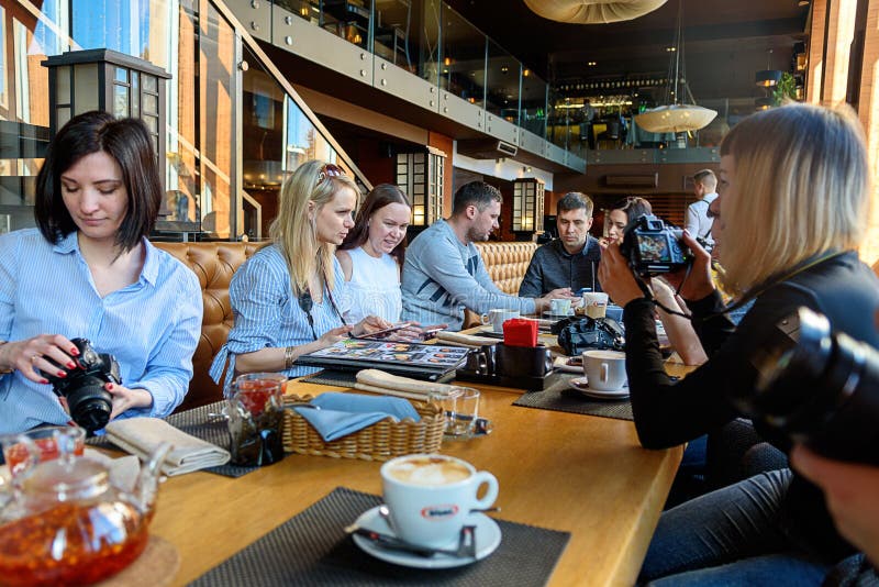 St Petersburg, marzec 24, 2019 Grupa cztery ludzie biznesu zbierał przy Śniadaniowym stołem, dyskutuje ciekawić zdjęcia stock St Petersburg, marzec 24, 2019 Grupa cztery ludzie biznesu zbierał przy Śniadaniowym stołem, dyskutuje ciekawić zdjęcia stock